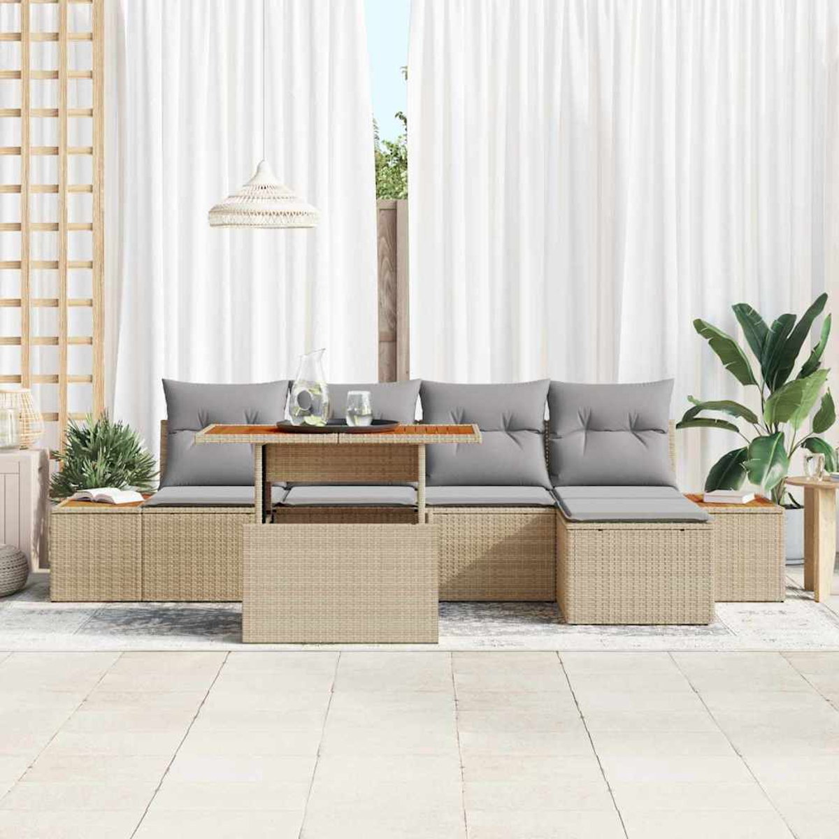 Gartenmöbel-Set aus Korbgeflecht mit grauen Kissen. Ein Tisch mit einem Glas Wasser und einer Pflanze im Hintergrund.