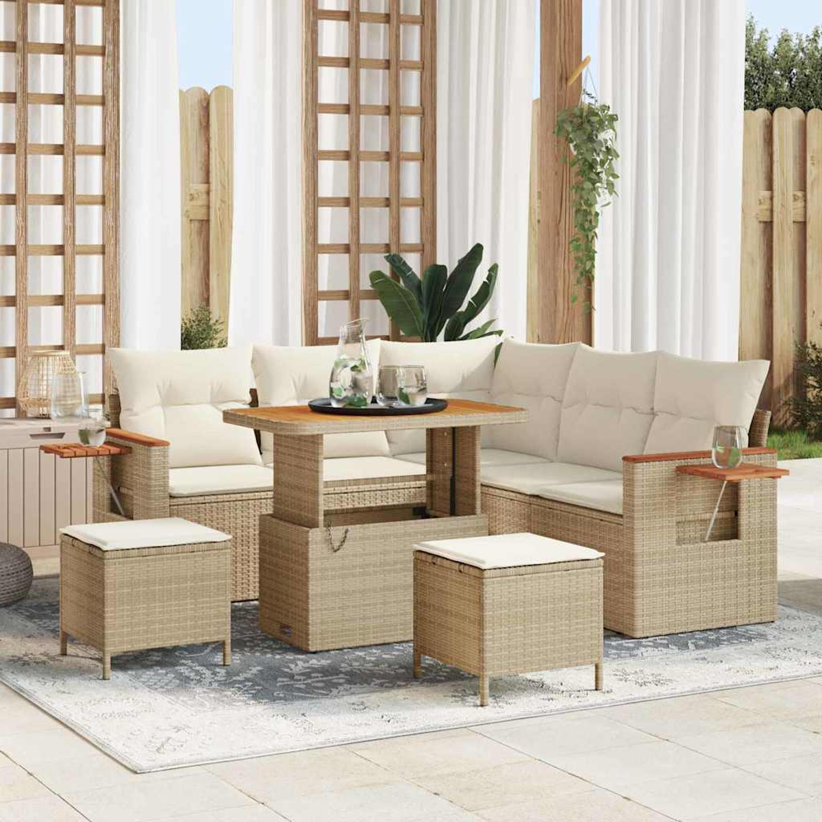Garten-Sitzgruppe mit beigen Kissen, einem Holztisch und zwei Ottomanen auf einem gemusterten Teppich. Weiße Vorhänge und Holzzaun im Hintergrund.