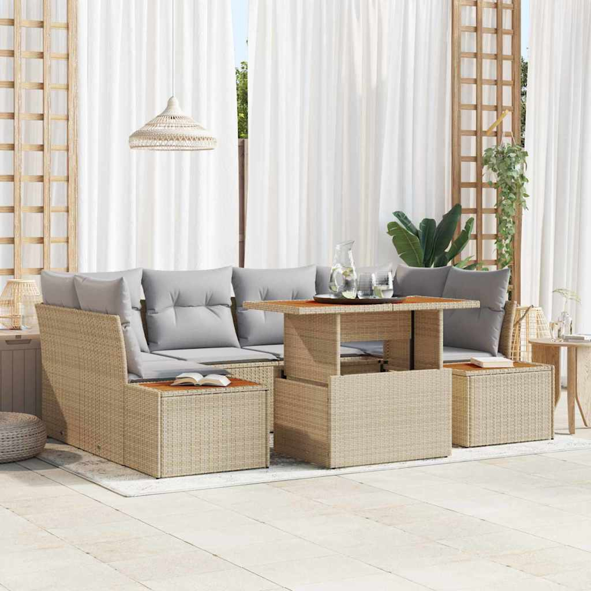 Rattan-Sofa-Set im Freien mit grauen Kissen, einem Tisch mit Hebefunktion und weißen Vorhängen im Hintergrund. Ein Buch liegt auf dem Sitz.