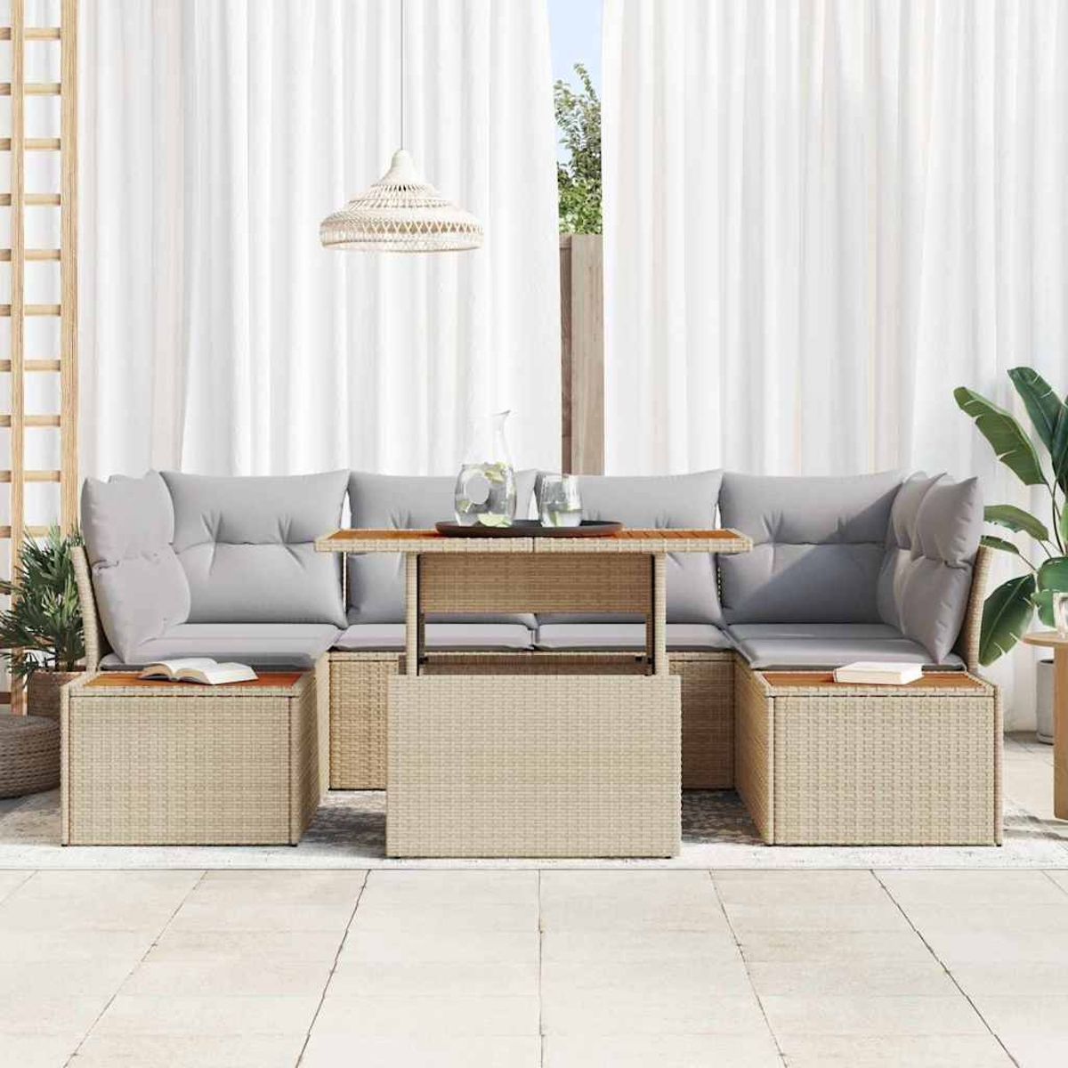 Gartenlounge-Set mit grauen Kissen und einem Tisch mit Hubfunktion. Mit Beistelltischen, weißen Vorhängen und einer Hängelampe.