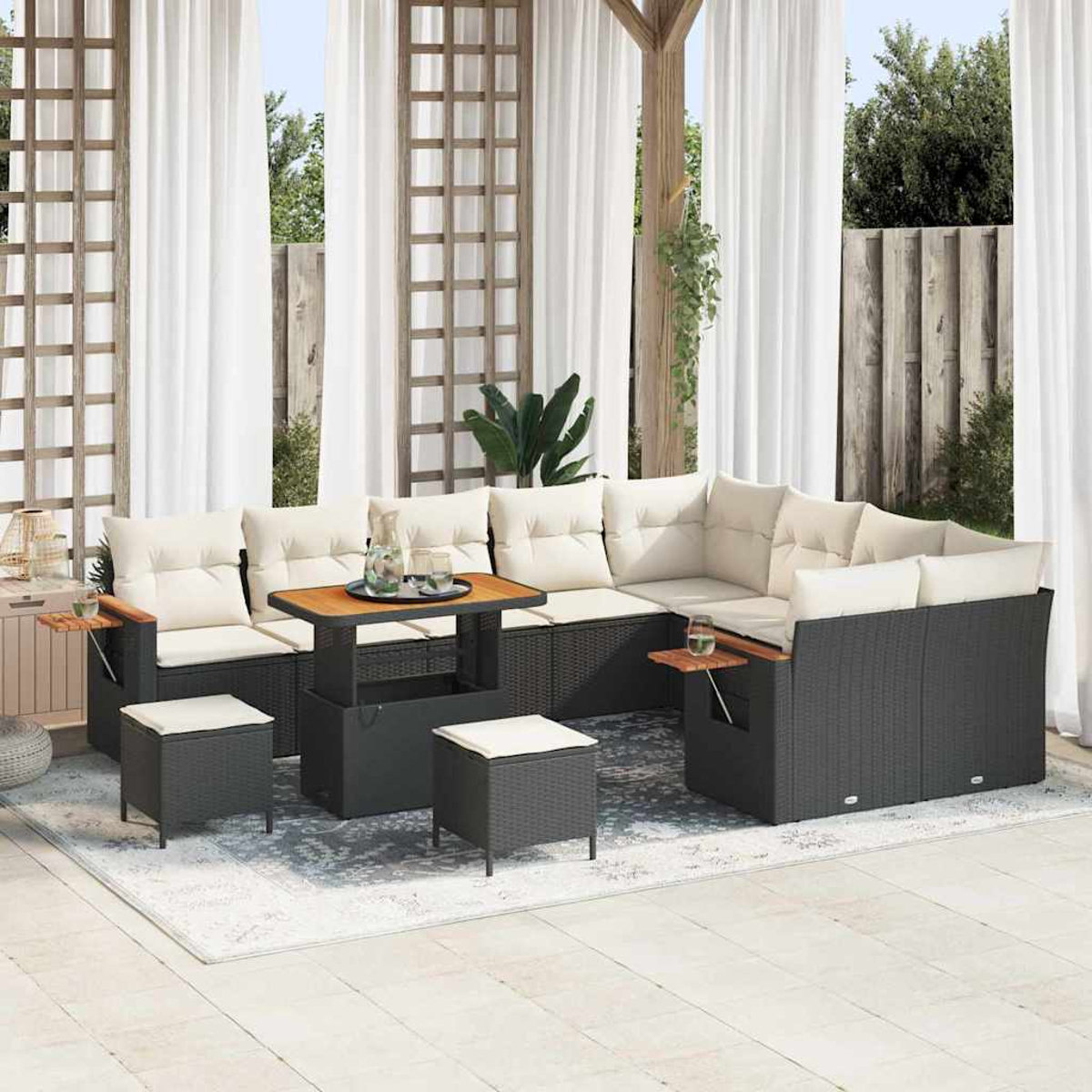 Garten-Set mit Ecksofa, Tisch und Hockern. Beige Kissen, dunkelgraues Korbgeflecht, Holzakzente und weiße Vorhänge.