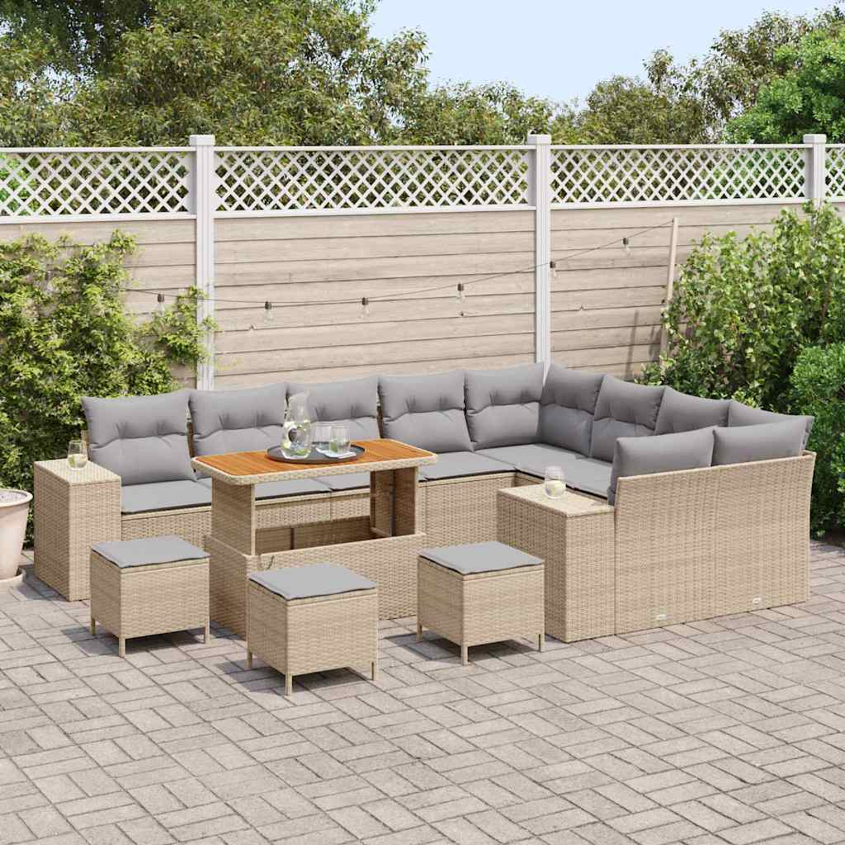 Un set da patio esterno con divano componibile, pouf e tavolo. Il set si trova su un patio in mattoni, con una recinzione e vegetazione sullo sfondo.