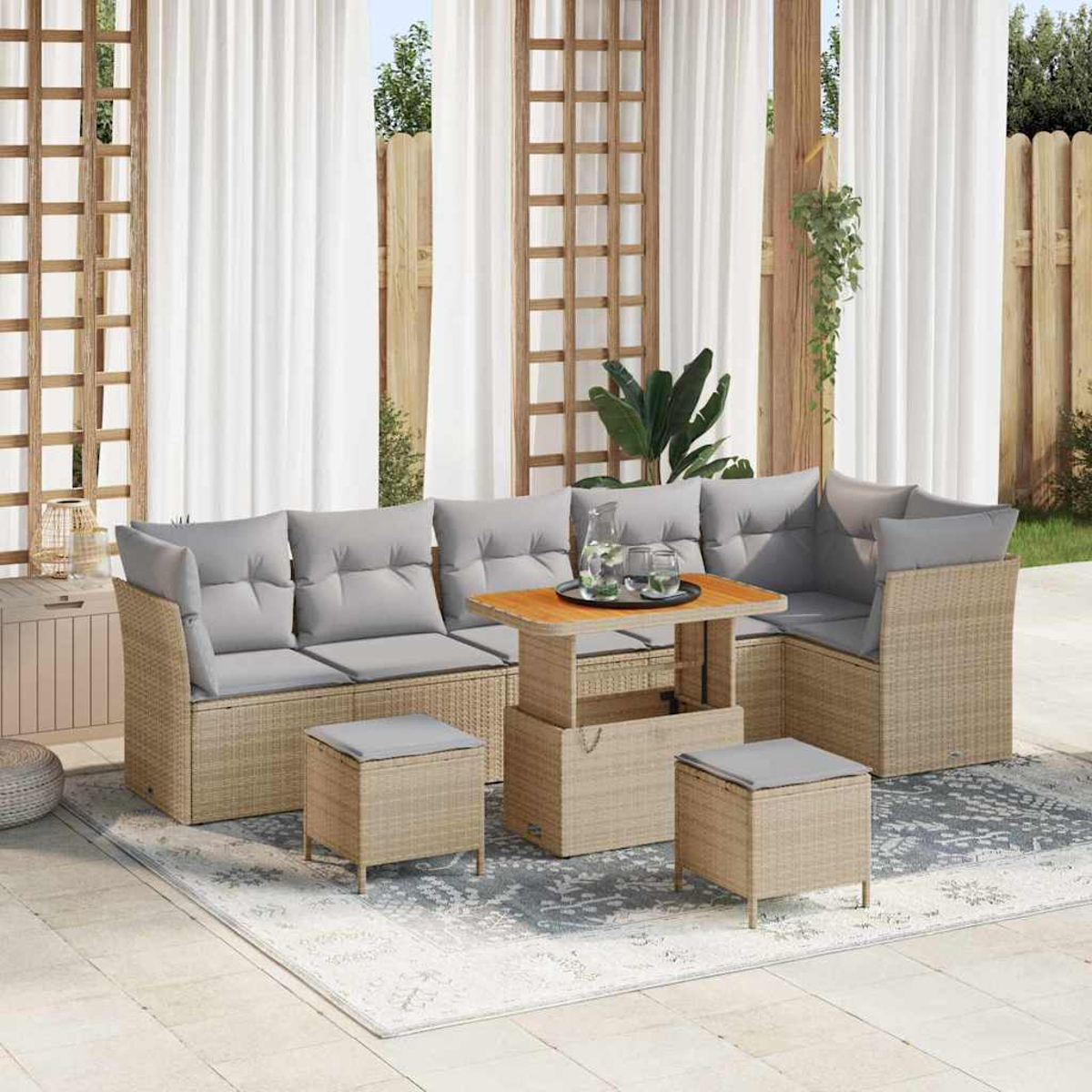 Outdoor-Rattan-Ecksofa mit grauen Kissen und einem Holztisch. Zwei Ottomanen stehen davor. Weiße Vorhänge im Hintergrund.