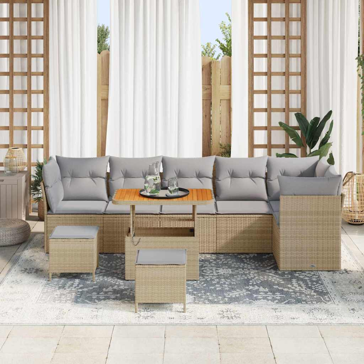 Garten-Sitzgruppe mit grauen Kissen, kleinem Tisch und Teppich. Weiße Vorhänge und Holzgitter im Hintergrund.