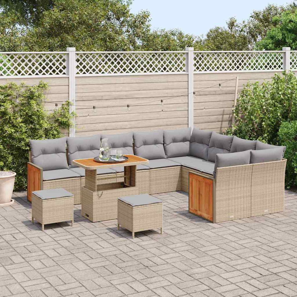 Outdoor-Ecksofa mit grauen Kissen und einem Holztisch auf einer Backstein-Terrasse. Ein weißer Zaun und Grünzeug im Hintergrund.