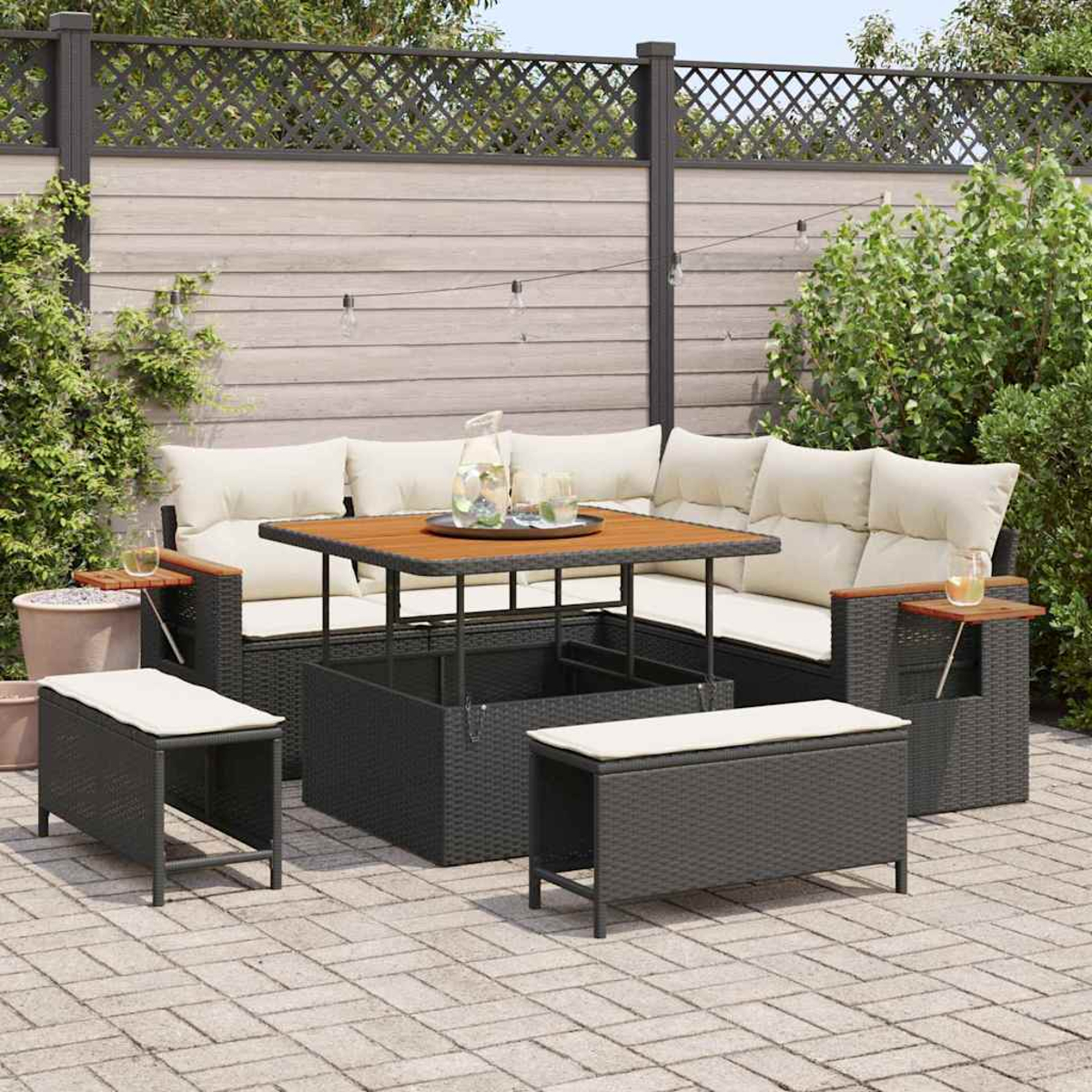 Terrassenset mit Tisch, Sofa und zwei Bänken. Der Tisch hat eine Holzplatte, das Sofa cremefarbene Kissen.