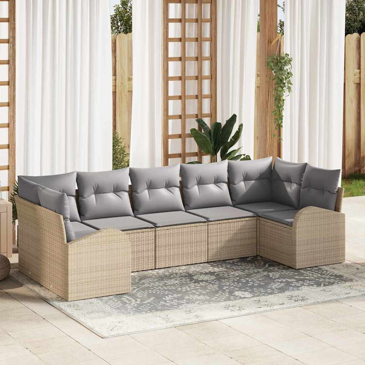 Outdoor-Ecksofa mit grauen Kissen. Beiger Korbrahmen auf einer Terrasse. Weiße Vorhänge und Holzgitter im Hintergrund.