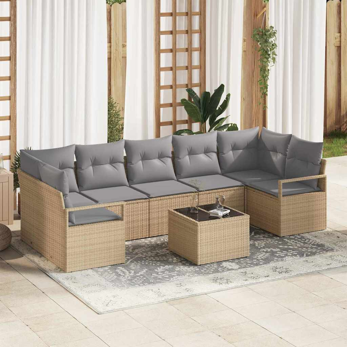 Outdoor-Ecksofa mit grauen Kissen und einem kleinen Tisch auf einem gemusterten Teppich, vor Vorhängen und Holzstrukturen.
