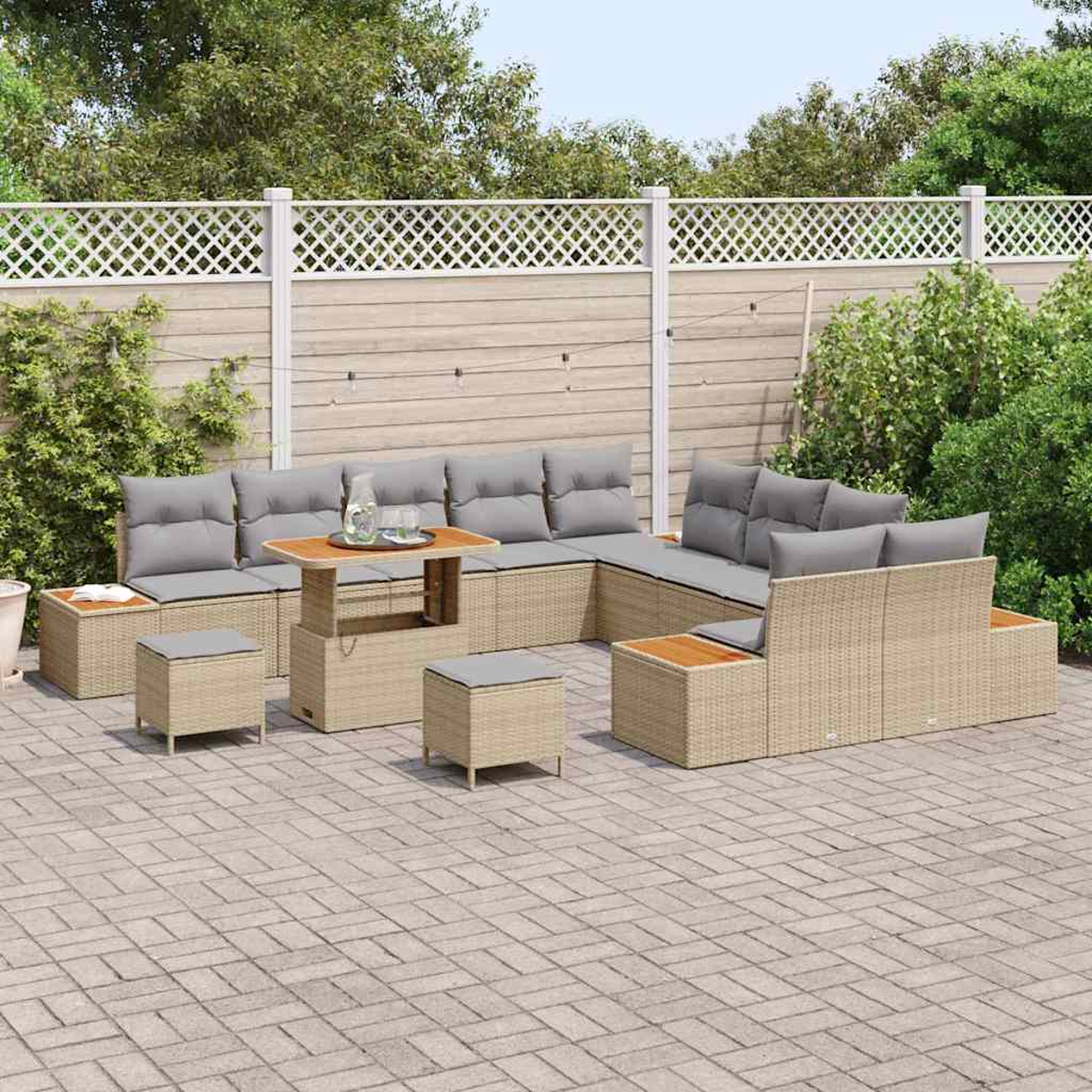 Rattan-Sofa für den Außenbereich mit grauen Kissen und Couchtisch. Gepflasterte Terrasse mit weißem Zaun und Grün im Hintergrund.