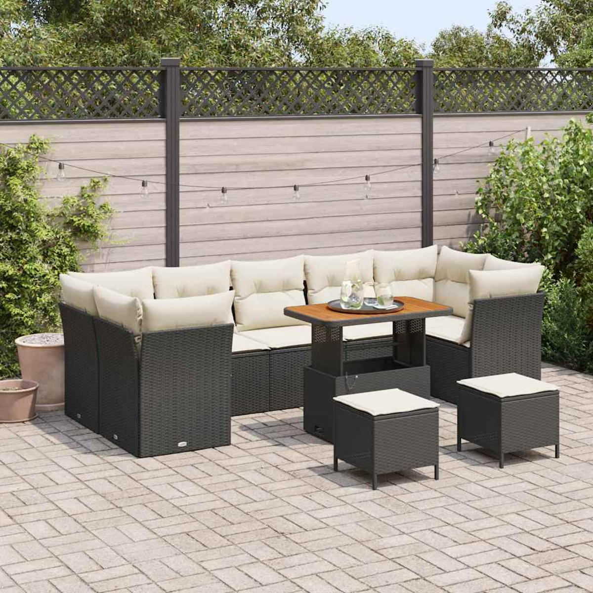 Set patio esterno con mobili in vimini grigi, cuscini beige e tavolo in legno. Su un patio in mattoni con recinzione e piante sullo sfondo.
