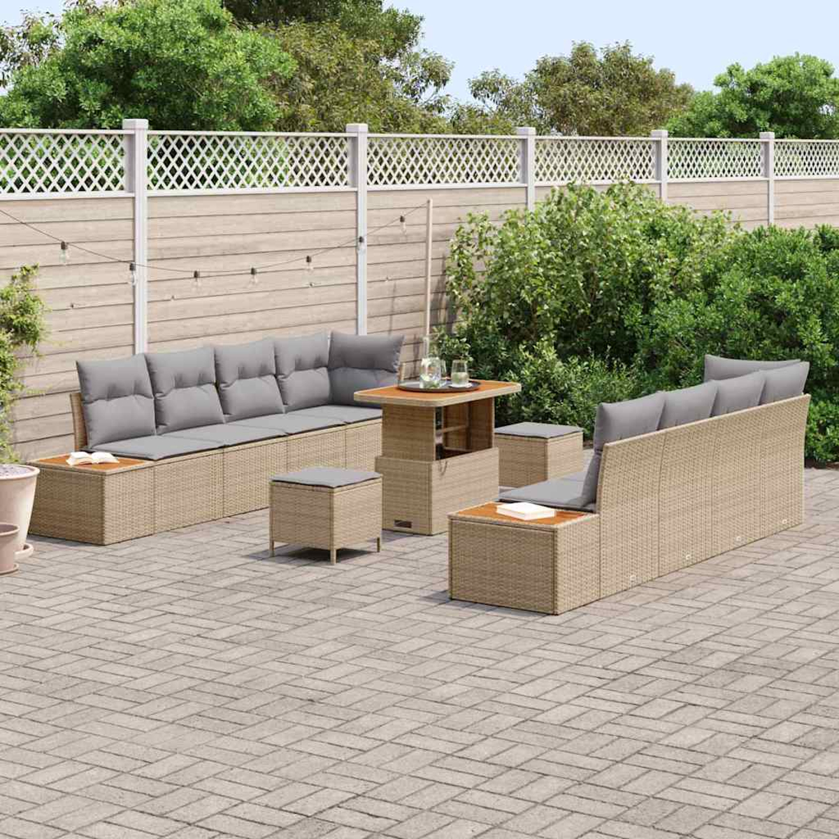 Juego de muebles de patio sobre patio de ladrillo. Incluye un sofá, dos sillas, una mesa y dos otomanas. Valla blanca y vegetación en el fondo.