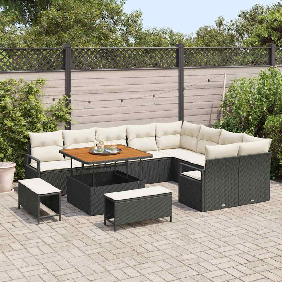 Outdoor-Ecksofa mit Tisch, zwei Bänken und Zaun im Hintergrund. Das Sofa hat cremefarbene Kissen. Der Tisch hat ein Tablett.