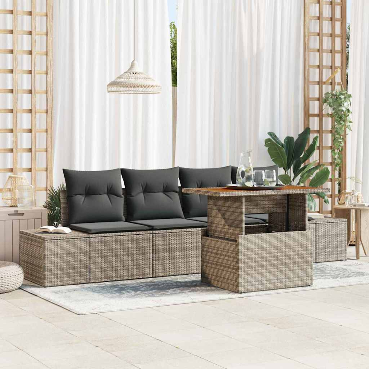 Outdoor-Sitzbereich mit gewebtem Sofa, Kissen, Tisch und Vorhängen. Pflanzen und eine Hängeleuchte dekorieren.