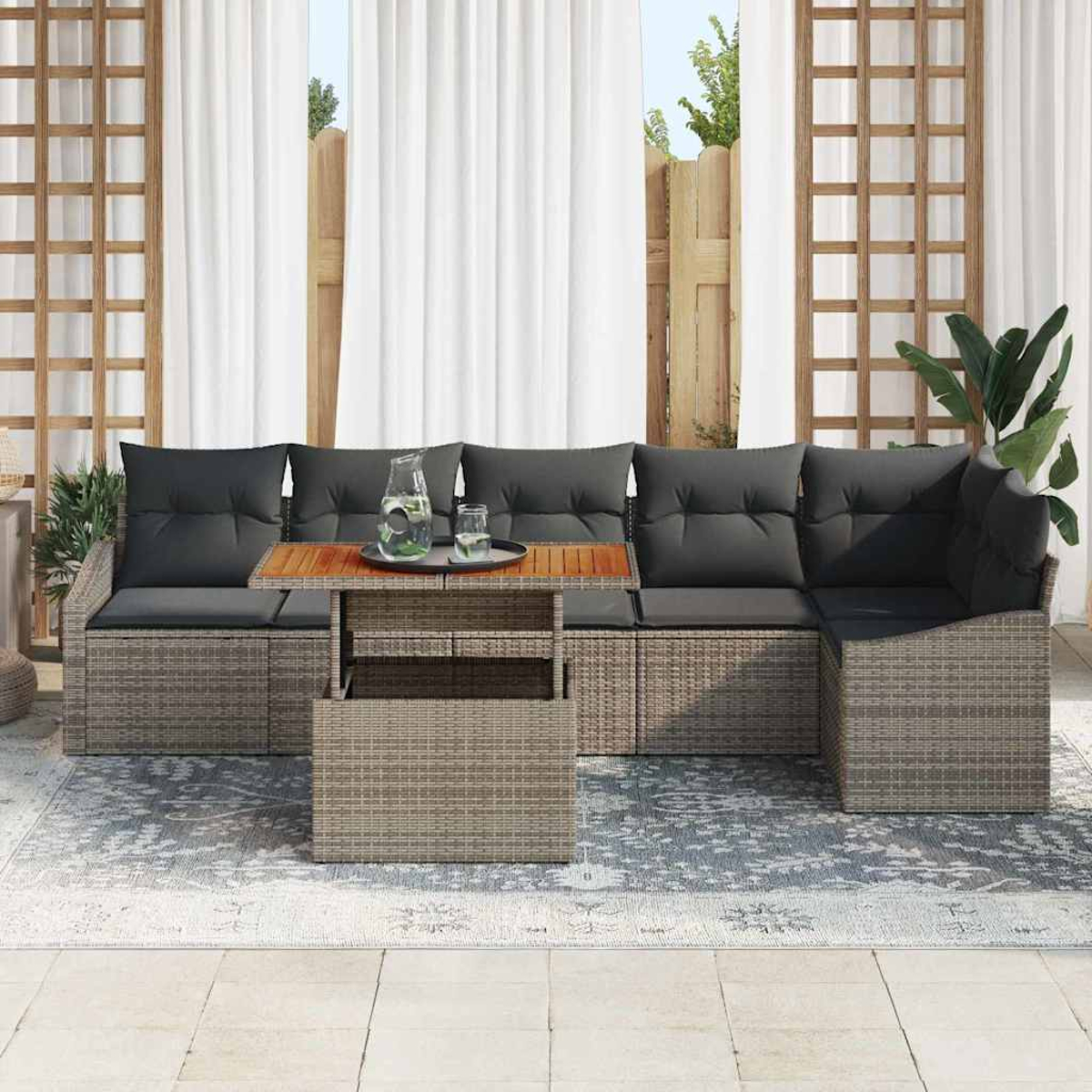 Outdoor-Ecksofa mit grauen Kissen und einem Holztisch. Weiße Vorhänge und ein Holzzaun sind im Hintergrund.