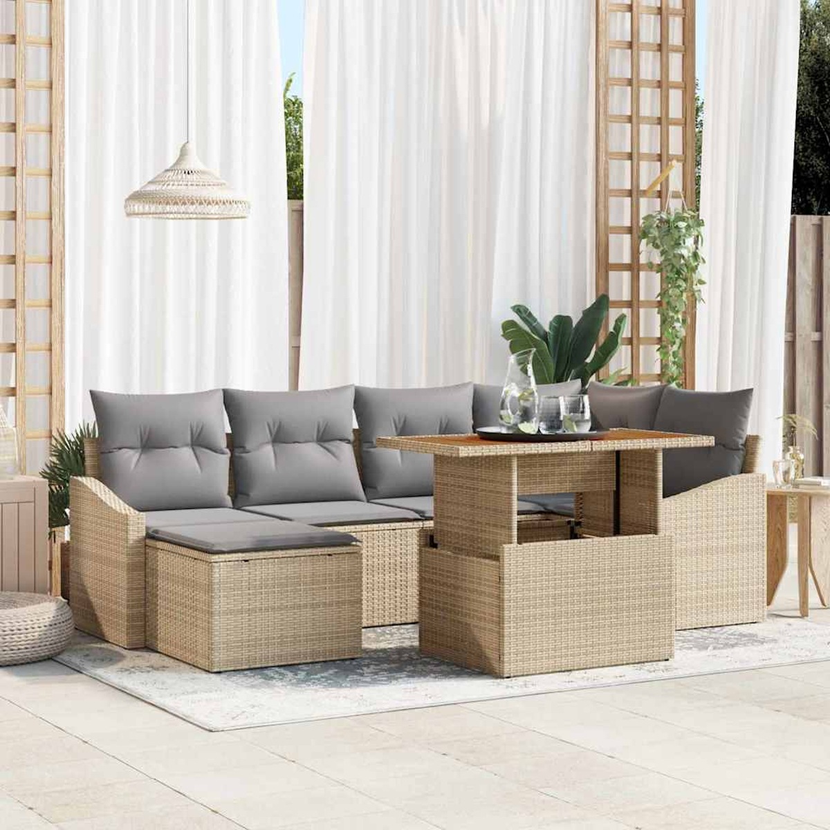 Geflecht-Terrassenmöbel mit grauen Kissen und einem Tisch. Weiße Vorhänge und eine Hängeleuchte sind im Hintergrund.