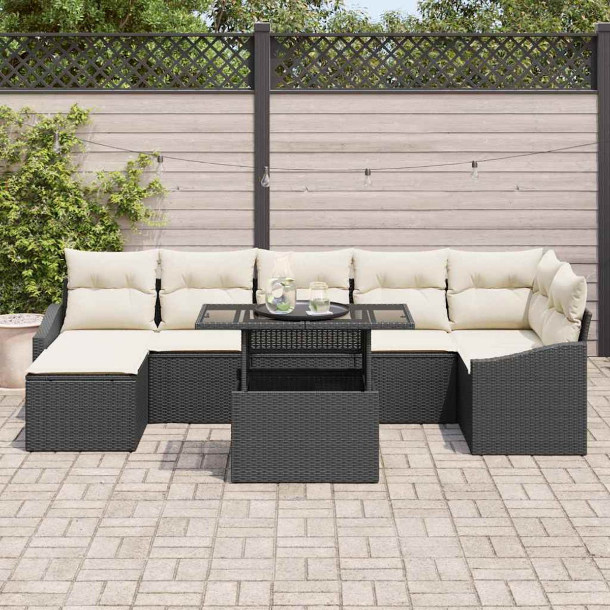 Ein Outdoor-Terrassenset mit Ecksofa, Tisch und Kissen, auf einer Ziegelterrasse platziert. Im Hintergrund befinden sich ein Zaun und Grün.
