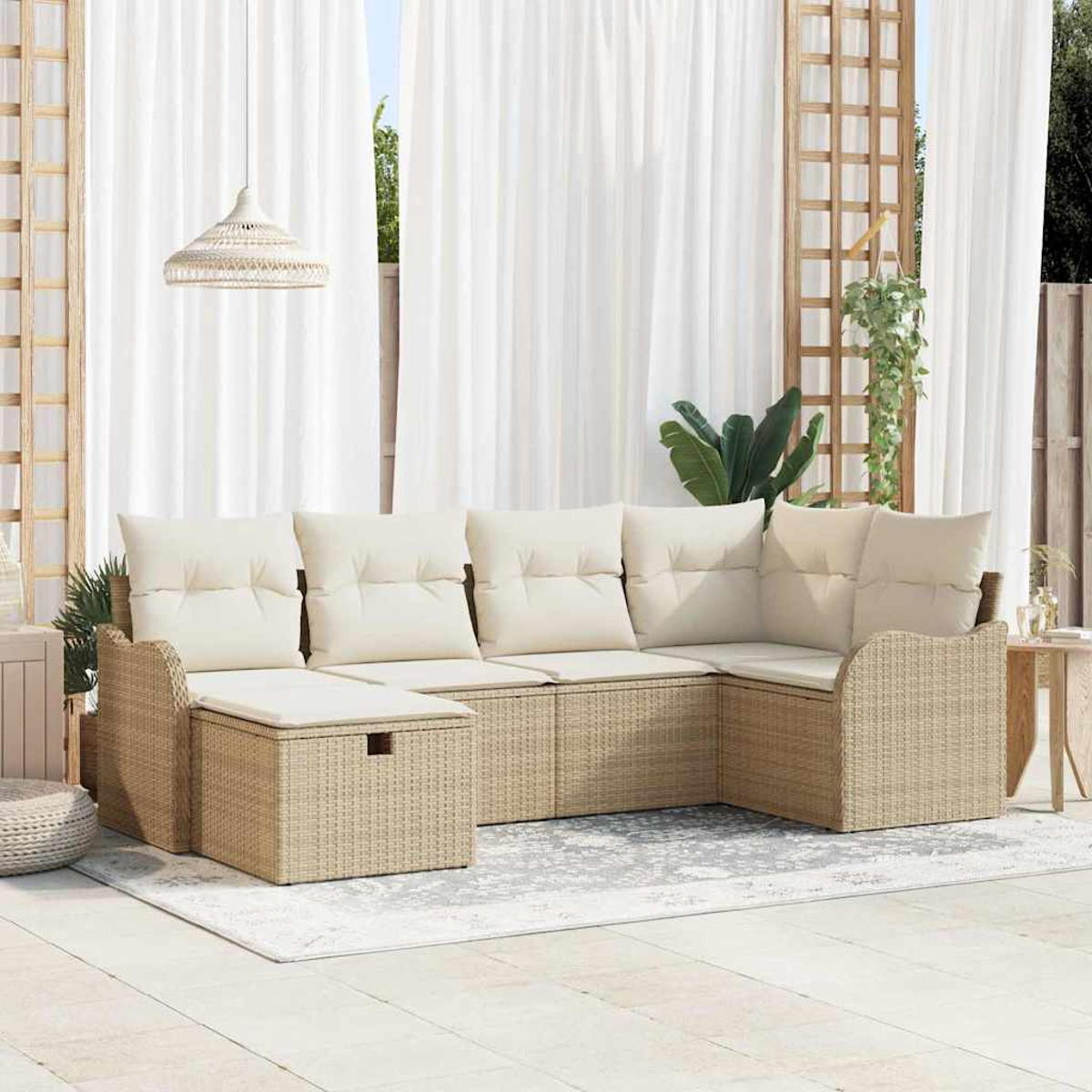 Outdoor-Ecksofa mit cremefarbenen Kissen. Beige Korbmöbel auf einer Terrasse mit Vorhängen, einer Hängeleuchte und einem kleinen Tisch.