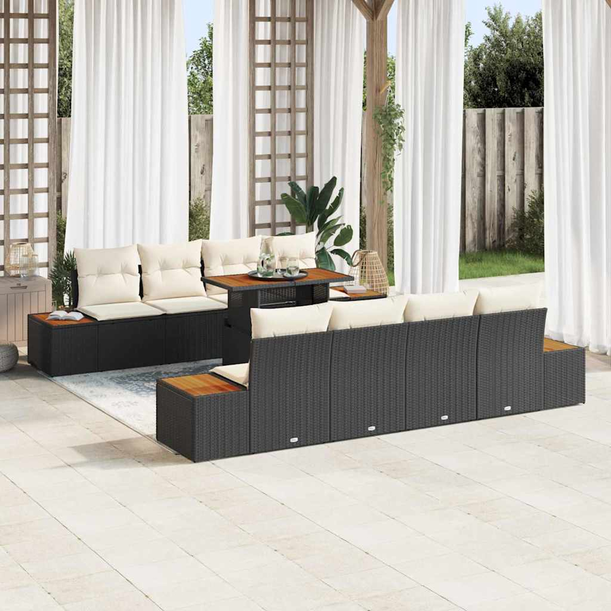 Gartenmöbel-Set mit schwarzen Korbs Sofas, beigen Kissen und einem Holztisch, Vorhänge im Hintergrund.