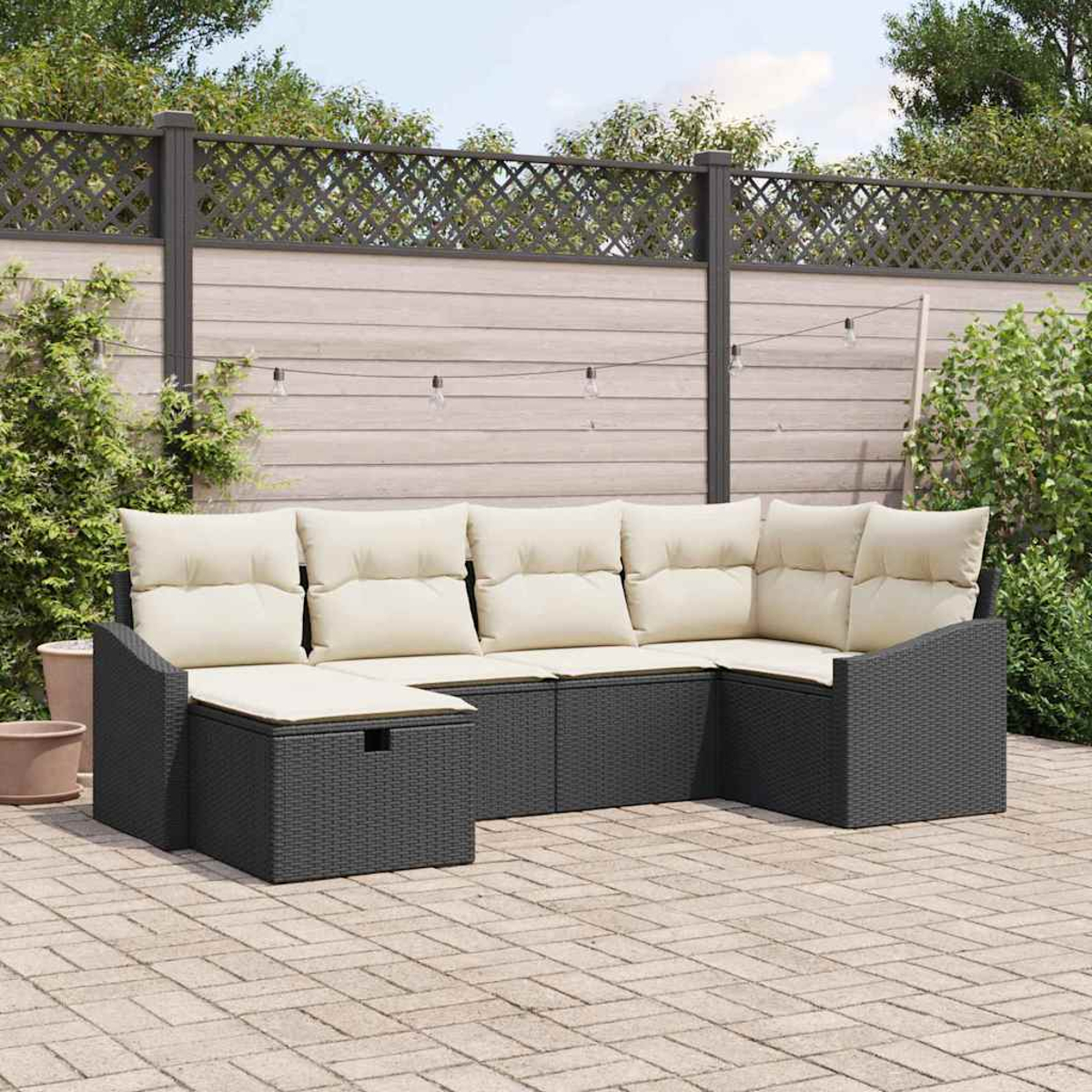 Outdoor-Ecksofa mit cremefarbenen Kissen auf einer Ziegelterrasse. Ein Holzzaun und Grünflächen befinden sich im Hintergrund.