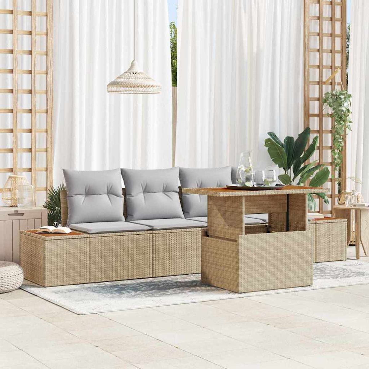 Outdoor-Sitzbereich mit beigen Korbmöbeln, grauen Kissen und einem Holztisch. Weiße Vorhänge und Pflanzen im Hintergrund.