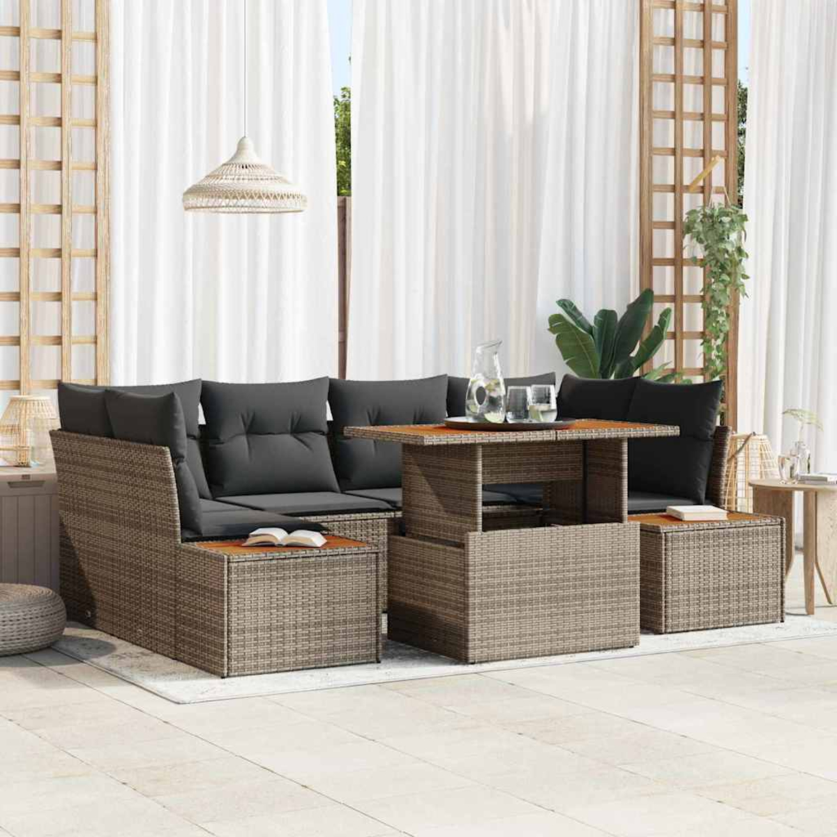 Outdoor-Sitzbereich mit grauen Kissen, einem Holztisch, einem weißen Vorhang und einer Hängelampe. Pflanzen sind im Hintergrund sichtbar.