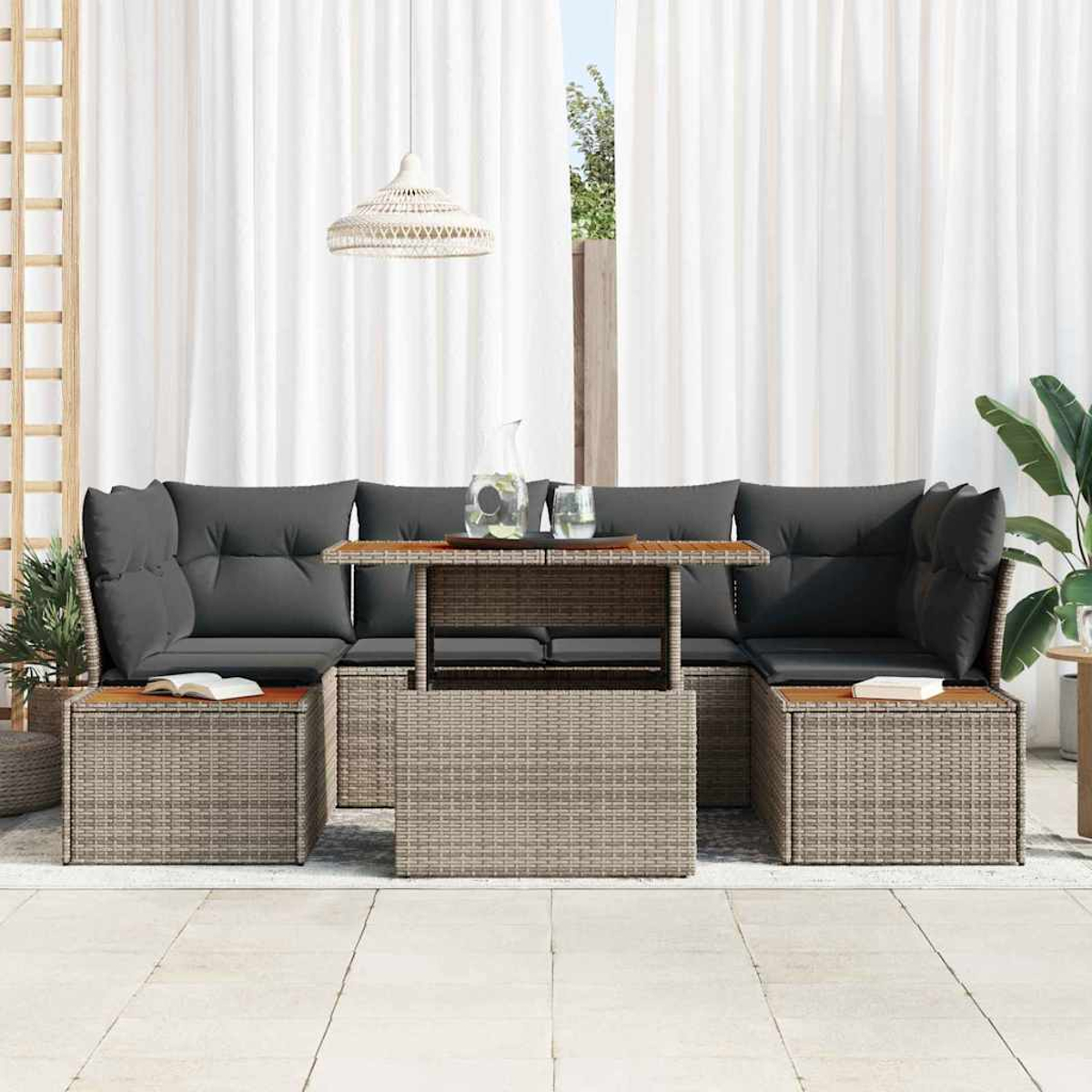Garten-Sitzgruppe mit grauen Kissen und Holztischen. Enthält Sofa, Couchtisch und Beistelltische mit Büchern. Weiße Vorhänge im Hintergrund.