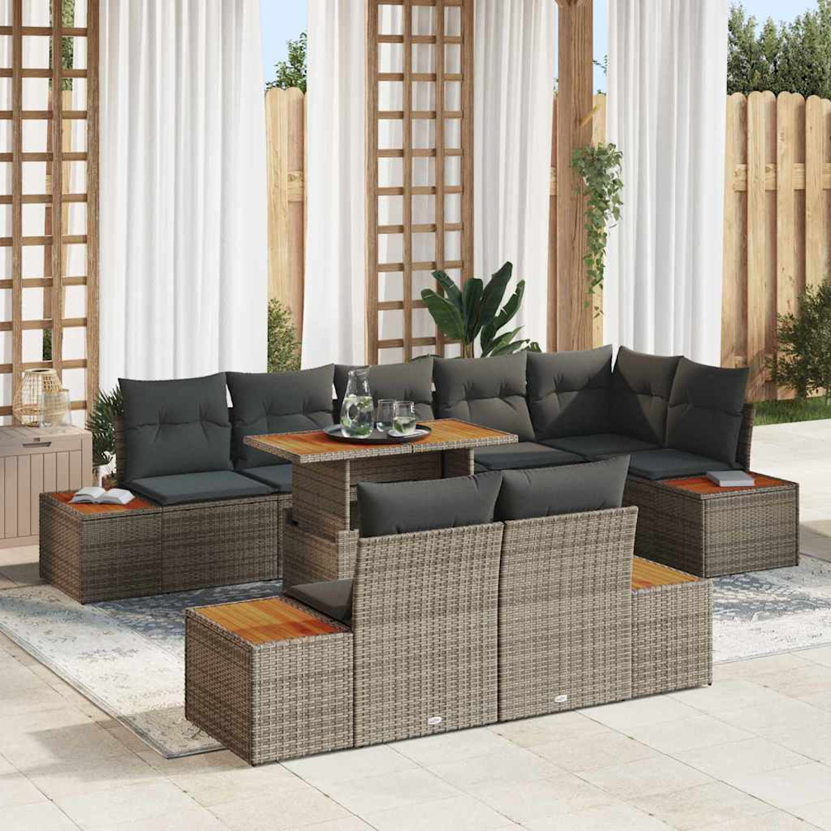 Sitzgruppe im Freien mit Kissen und Tisch auf einer Terrasse mit Vorhängen und Holzzaun.