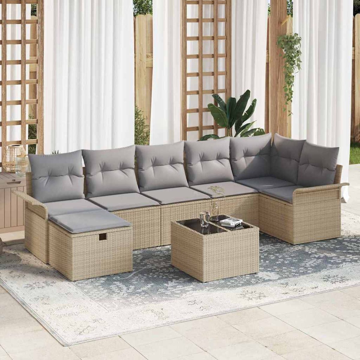 Geflochtenes Ecksofa mit grauen Kissen, Couchtisch und Teppich. Weiße Vorhänge und Holzgitter im Hintergrund.
