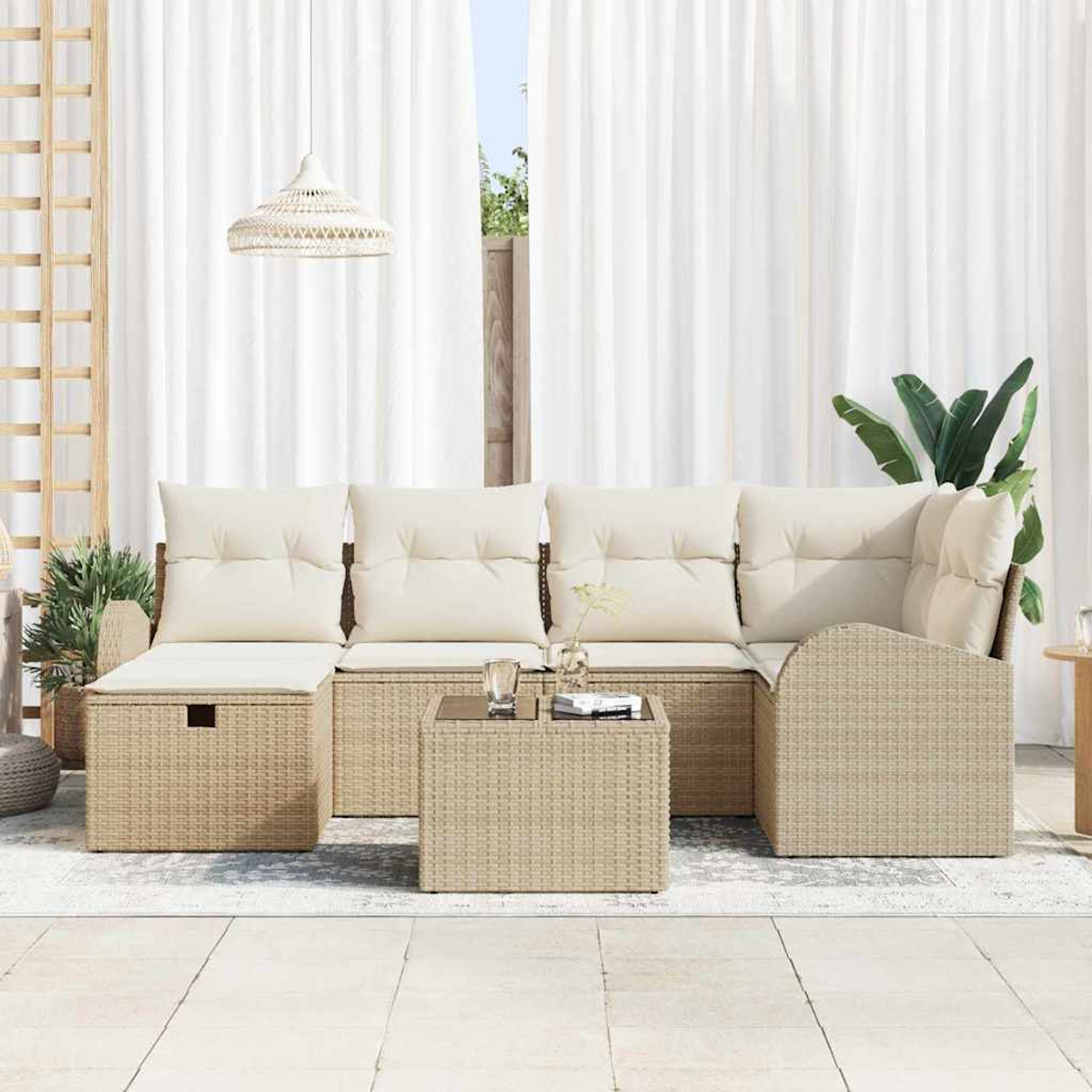 Ein Outdoor-Terrassenset mit beigen Korbmöbeln, cremefarbenen Kissen und einem kleinen Tisch. Weiße Vorhänge und Pflanzen sind im Hintergrund.