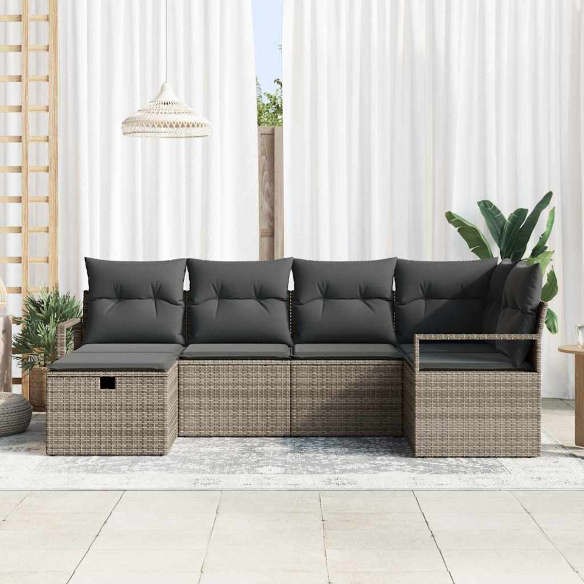 Outdoor-Ecksofa mit grauen Kissen auf einer Terrasse. Weiße Vorhänge und Pflanzen im Hintergrund. Eine Leuchte ist sichtbar.