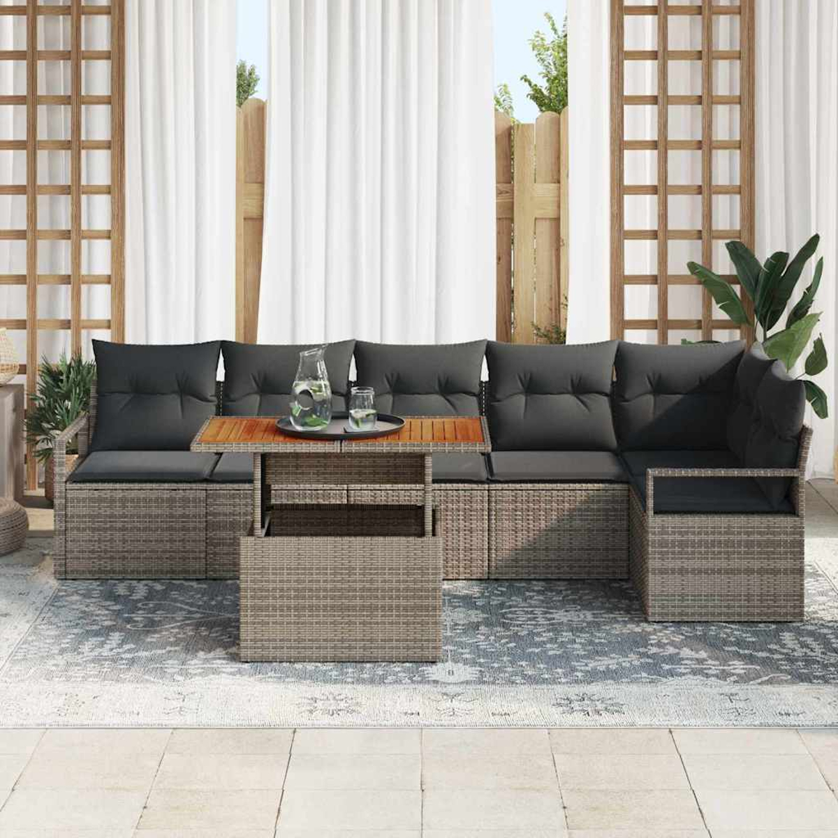 Outdoor-Ecksofa mit grauen Kissen und einem Holztisch. Weiße Vorhänge und ein Zaun befinden sich im Hintergrund.