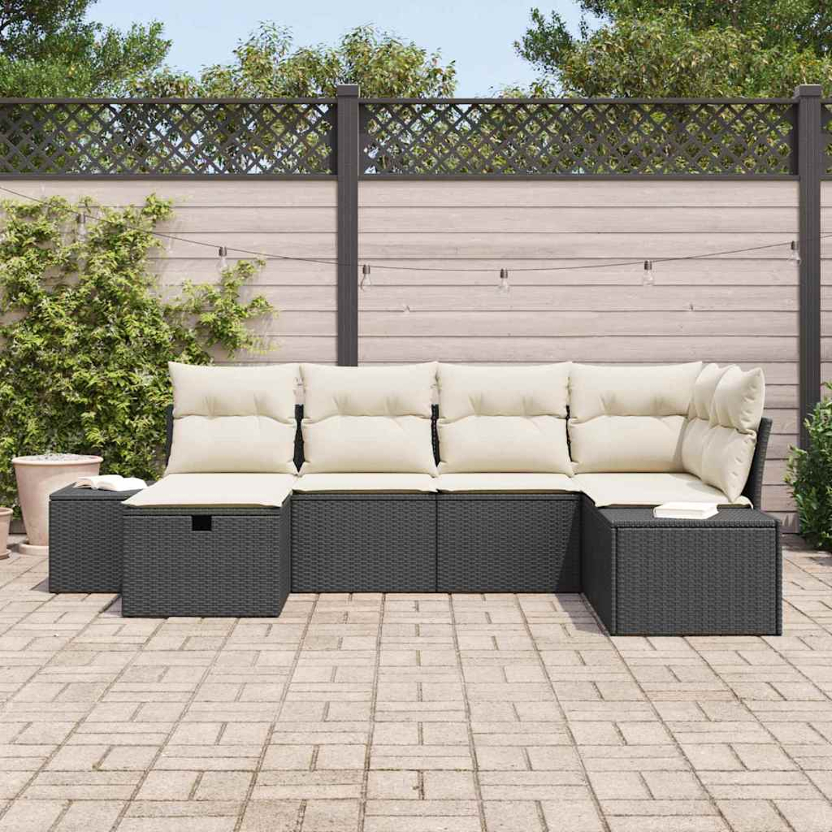 Ein Ecksofa im Freien mit cremefarbenen Kissen steht auf einer Terrasse. Im Hintergrund befinden sich ein Holzzaun und Grün.