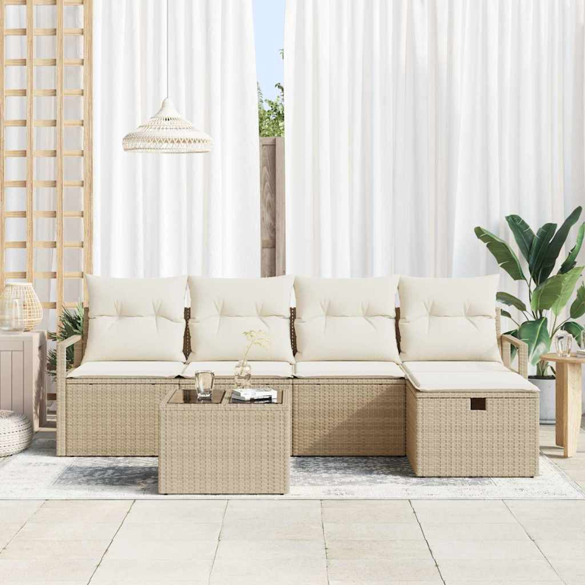 Sofá de mimbre beige para exteriores con cojines crema, mesa de cristal, cortinas blancas y una planta. La escena está en un patio.