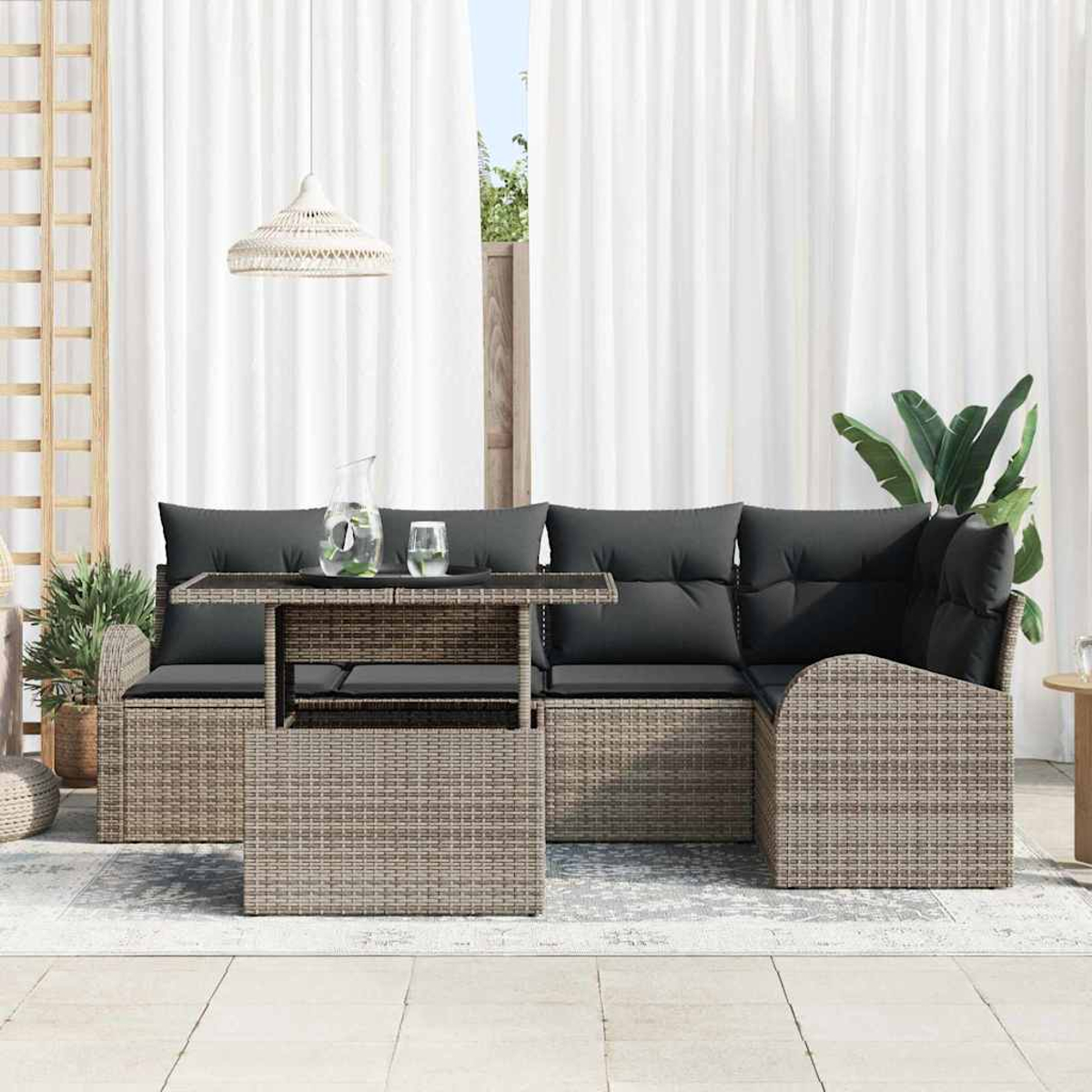 Gartenmöbel mit grauen Kissen und einem Tisch. Weiße Vorhänge im Hintergrund, eine Pflanze und eine Hängelampe.
