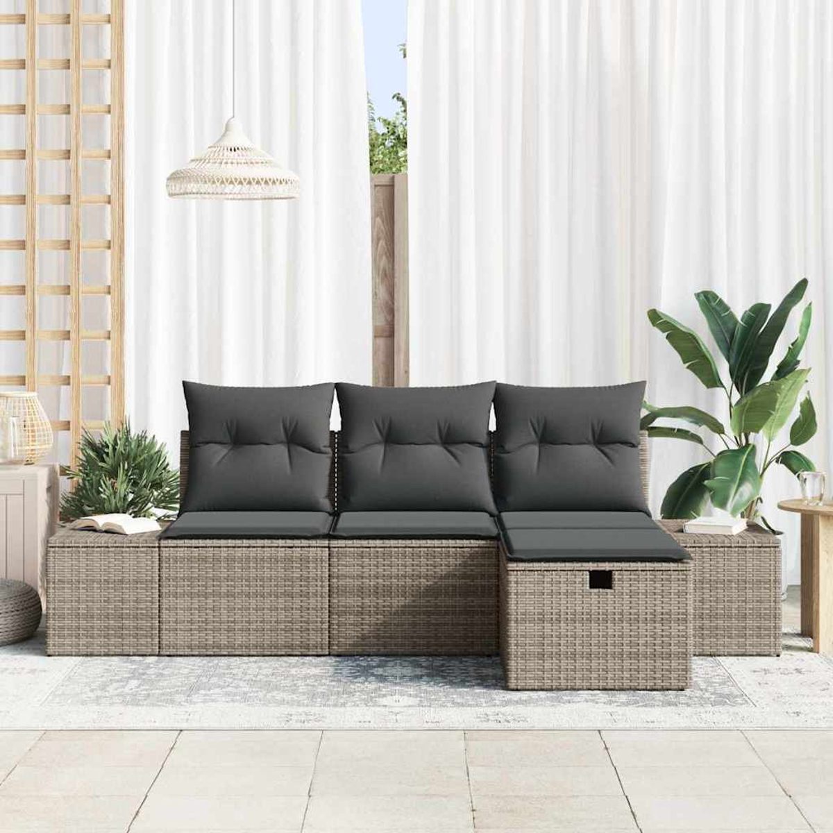 Ein graues Outdoor-Sofa mit Kissen steht auf einer Terrasse. Weiße Vorhänge, eine Lampe und Pflanzen sind im Hintergrund zu sehen.
