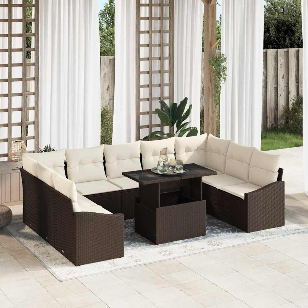 Outdoor-Ecksofa mit beigen Kissen, braunem Korbgewebe und einem Couchtisch mit Hebefunktion. Weiße Vorhänge und Grünpflanzen im Hintergrund.