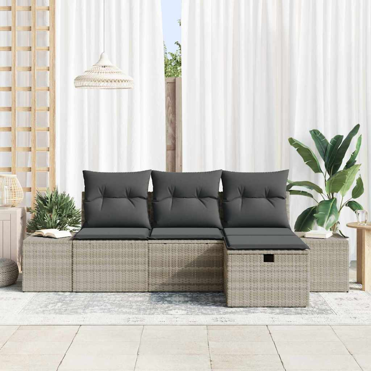 Rattansofa im Freien mit grauen Kissen. Weiße Vorhänge im Hintergrund. Eine Pflanze und eine Lampe sind ebenfalls sichtbar.