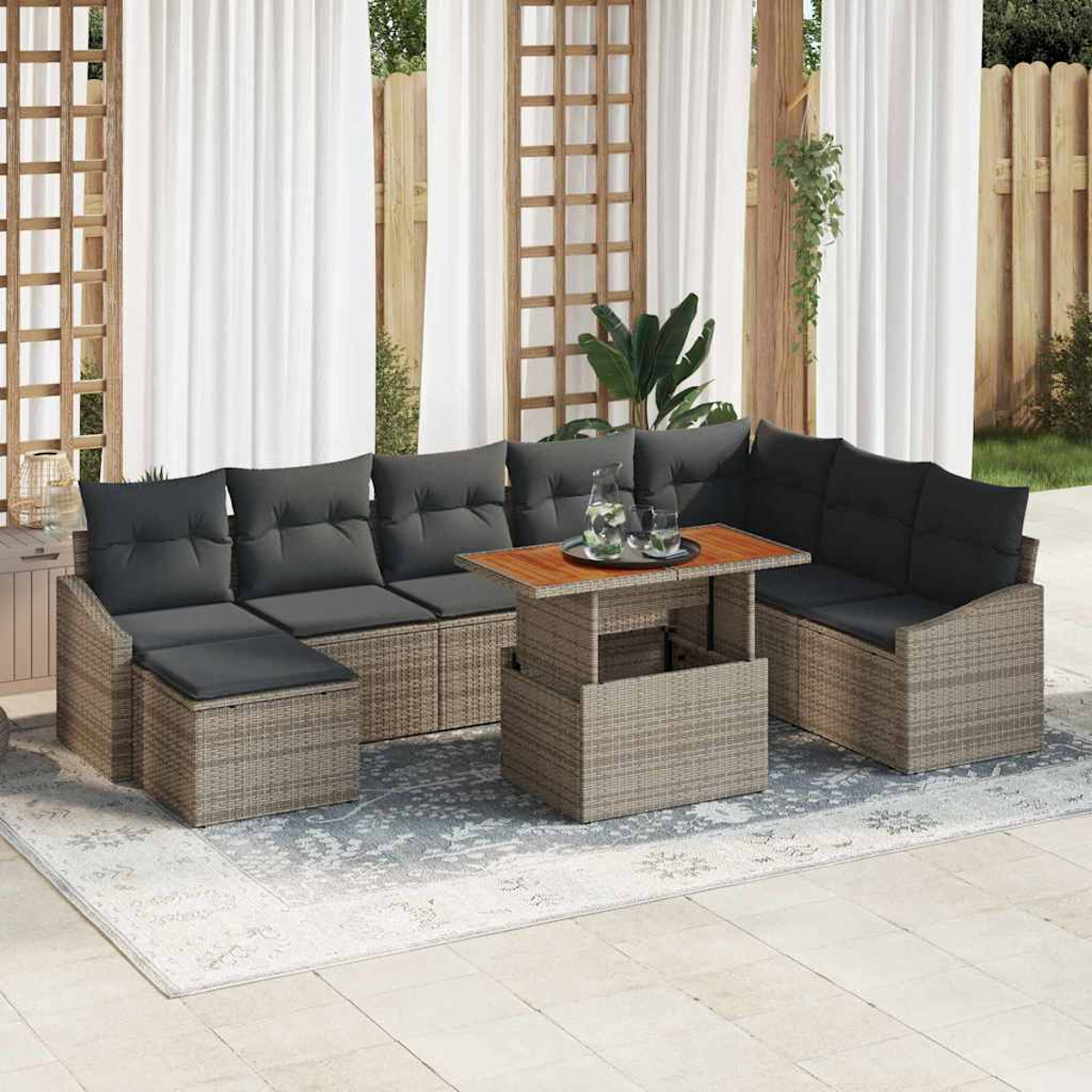 Outdoor-Ecksofa mit grauen Kissen und einem Holztisch auf einem gemusterten Teppich. Vorhänge im Hintergrund.