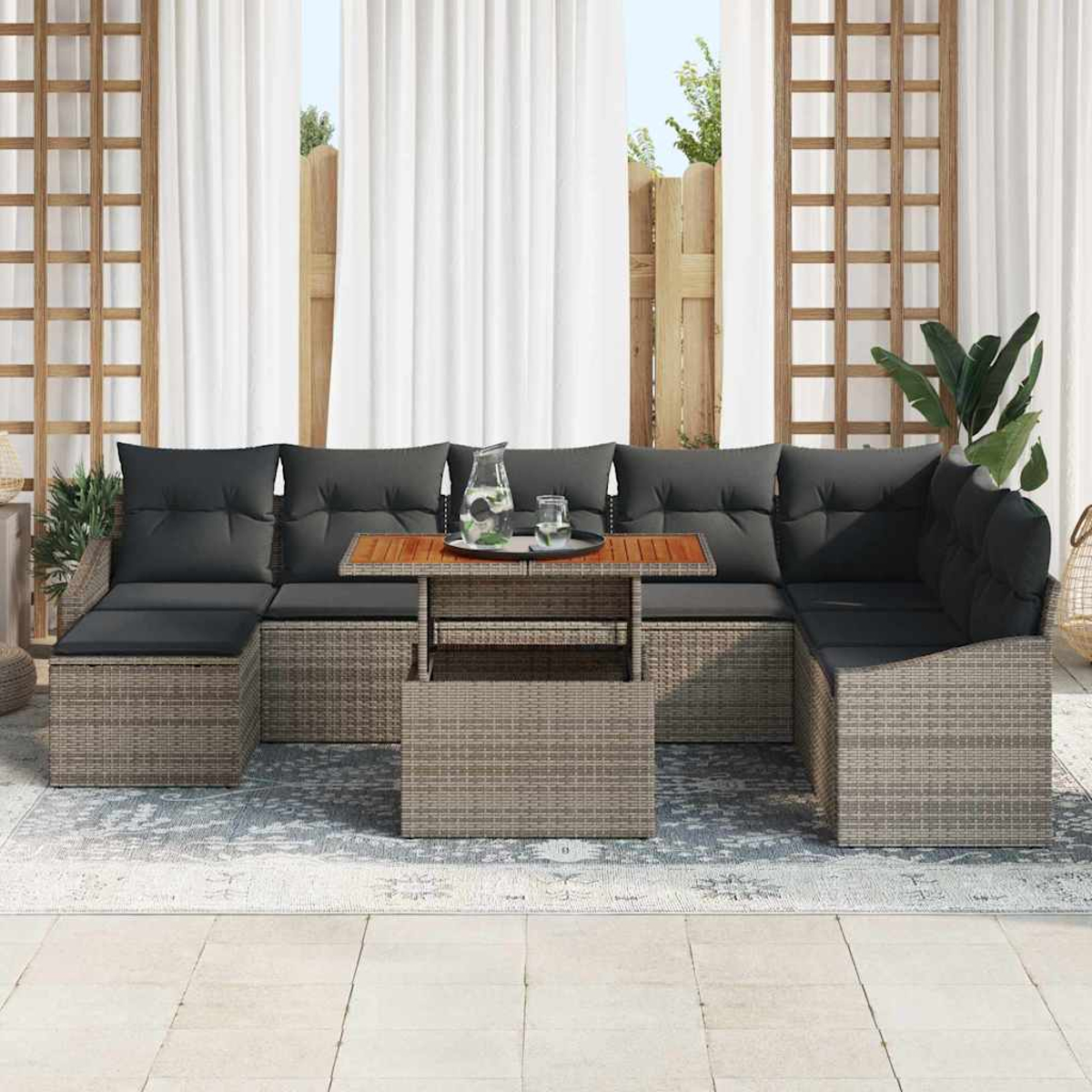 Outdoor-Ecksofa mit grauen Kissen, Holztisch mit Wasser und Glas. Weiße Vorhänge sind im Hintergrund.