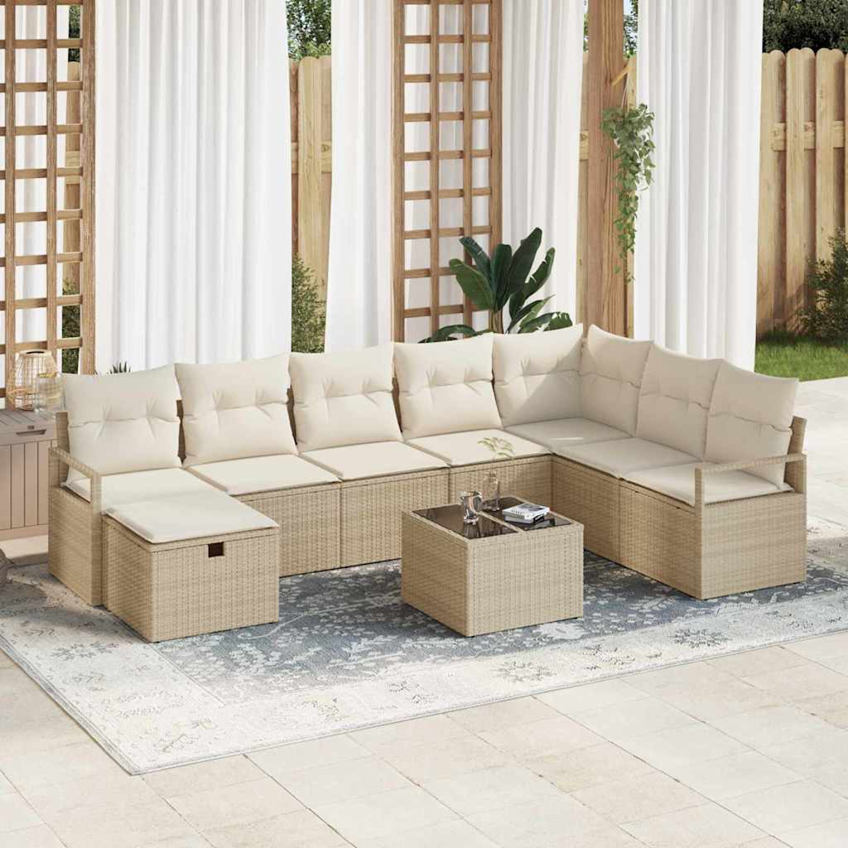 Gartensofa mit cremefarbenen Kissen und gewebter Basis. Ein kleiner Tisch mit Getränken steht auf einem gemusterten Teppich.