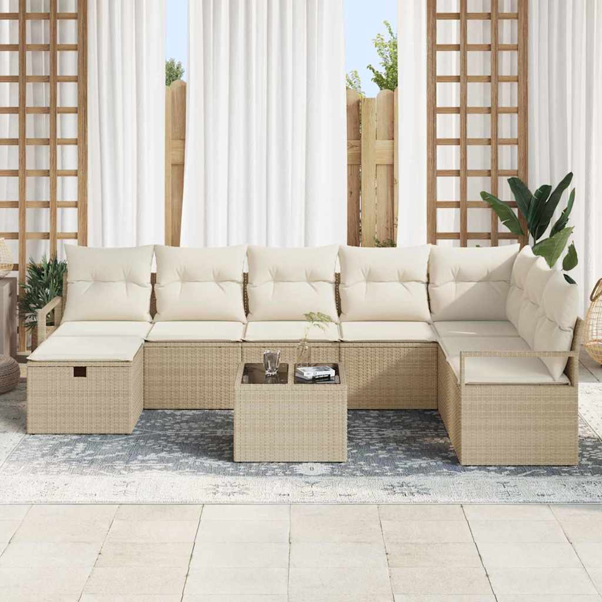 Outdoor-Ecksofa mit cremefarbenen Kissen, kleinem Tisch, Teppich, weißen Vorhängen und Holzgitter vor hellem Himmel.