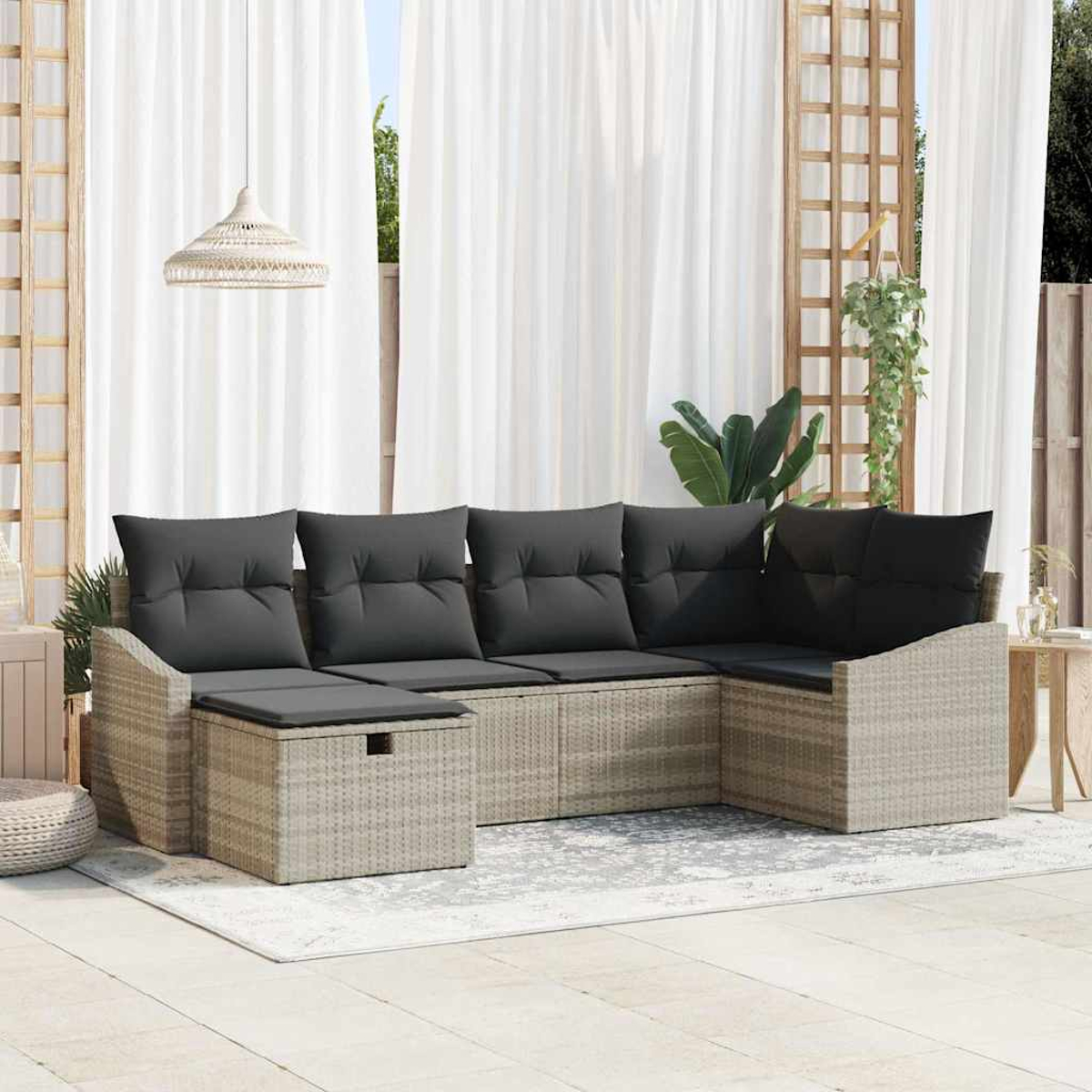 Outdoor-Ecksofa mit grauen Kissen auf einem gemusterten Teppich. Weiße Vorhänge im Hintergrund. Eine Hängelampe ist ebenfalls sichtbar.