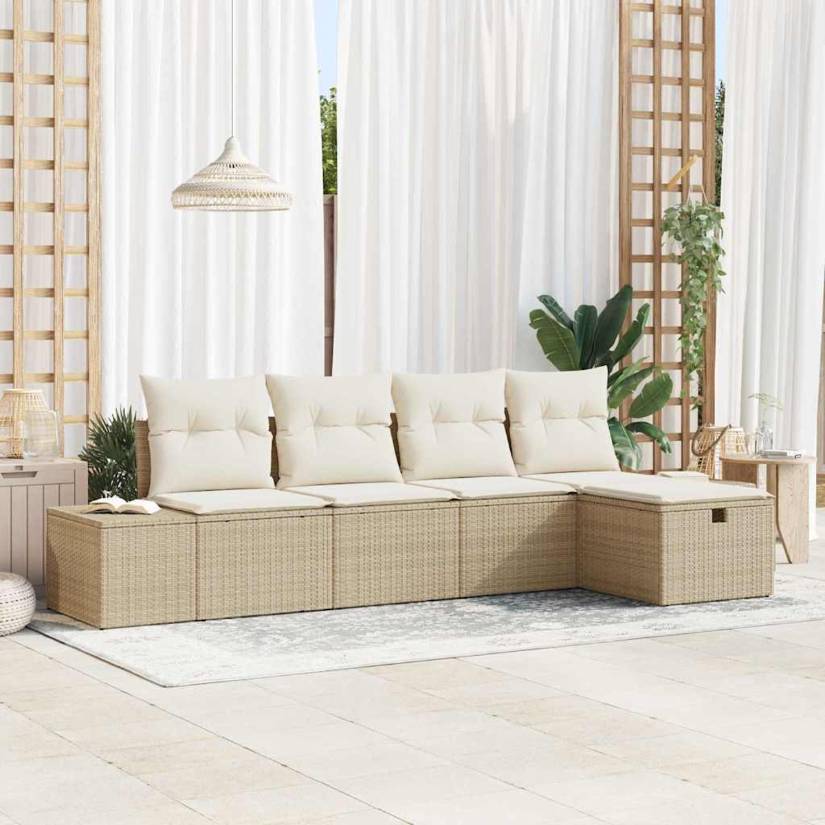 Sitzbereich im Freien. Beiges Korbansofa mit weißen Kissen. Weiße Vorhänge im Hintergrund. Pflanzen und Holzgitter sind sichtbar.
