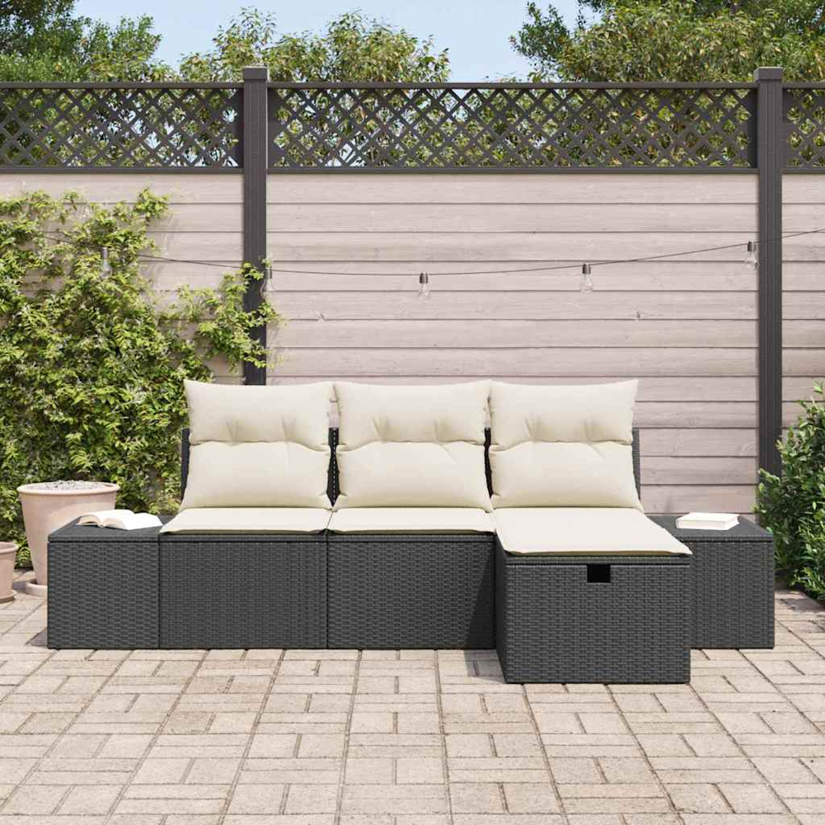 Garten-Sitzgruppe mit beigen Kissen, grauem Webrahmen und einem Holzzaun-Hintergrund mit Pflanzen und einer Backstein-Terrasse.