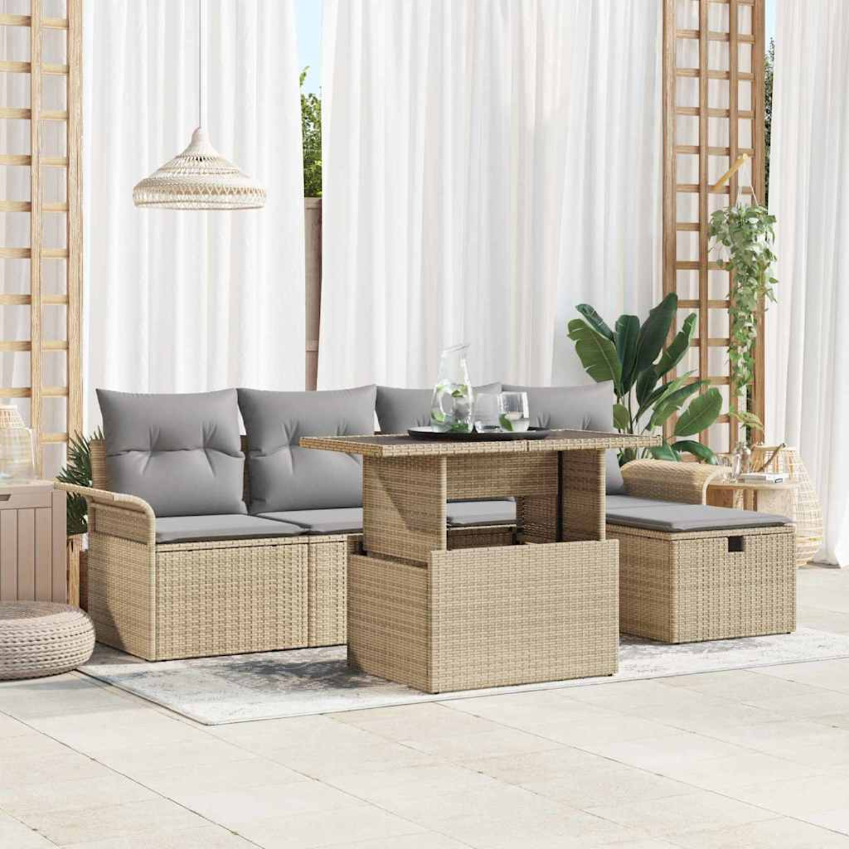 Terrassen-Set im Freien mit gewebtem Tisch und Sitzgelegenheiten, grauen Kissen, weißen Vorhängen und einer Hängeleuchte.