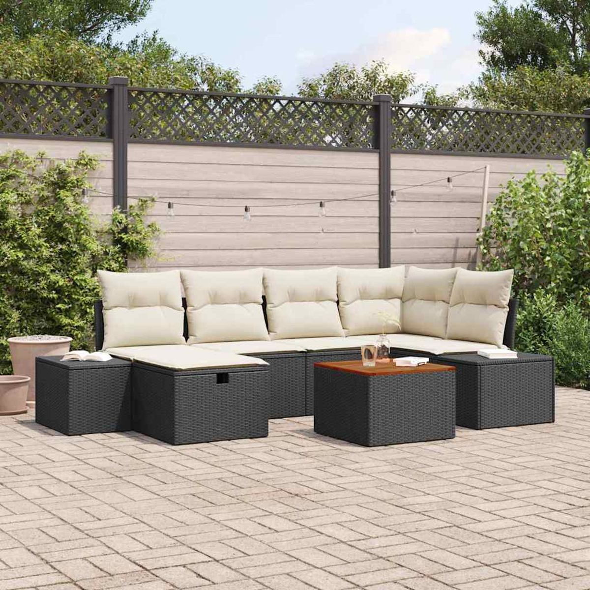 Outdoor-Ecksofa mit cremefarbenen Kissen, umgeben von schwarzen Korbstühlen und einem Couchtisch mit Holzplatte, auf einer Ziegelterrasse.