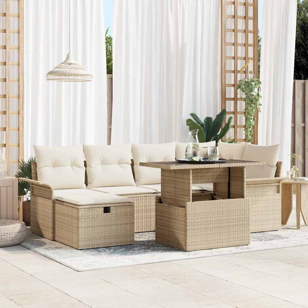 Rattansofa im Freien mit beigefarbenen Kissen, einem Tisch und weißen Vorhängen. Pflanzen und eine Hängelampe sind ebenfalls zu sehen.