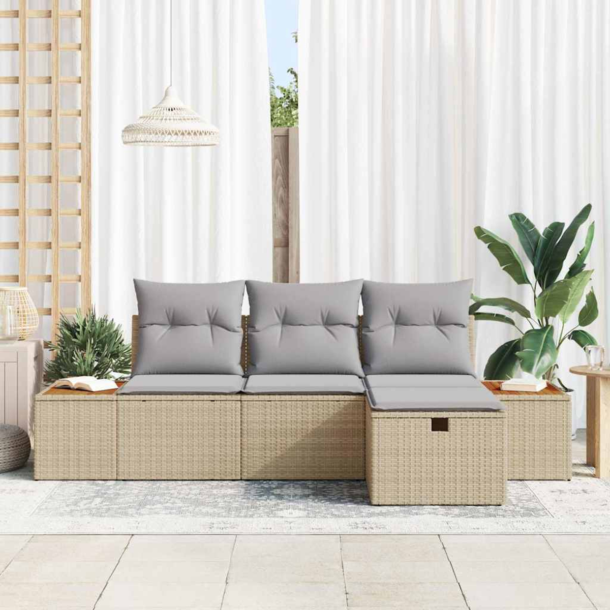 Korbmöbel-Sofa mit grauen Kissen vor weißen Vorhängen und Zimmerpflanzen.
