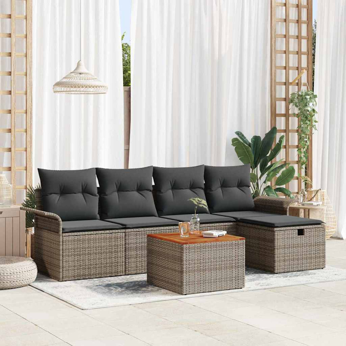 Garten-Sitzgruppe mit grauen Kissen. Enthält ein Sofa, eine Ottomane und einen Couchtisch. Weiße Vorhänge und Pflanzen im Hintergrund.