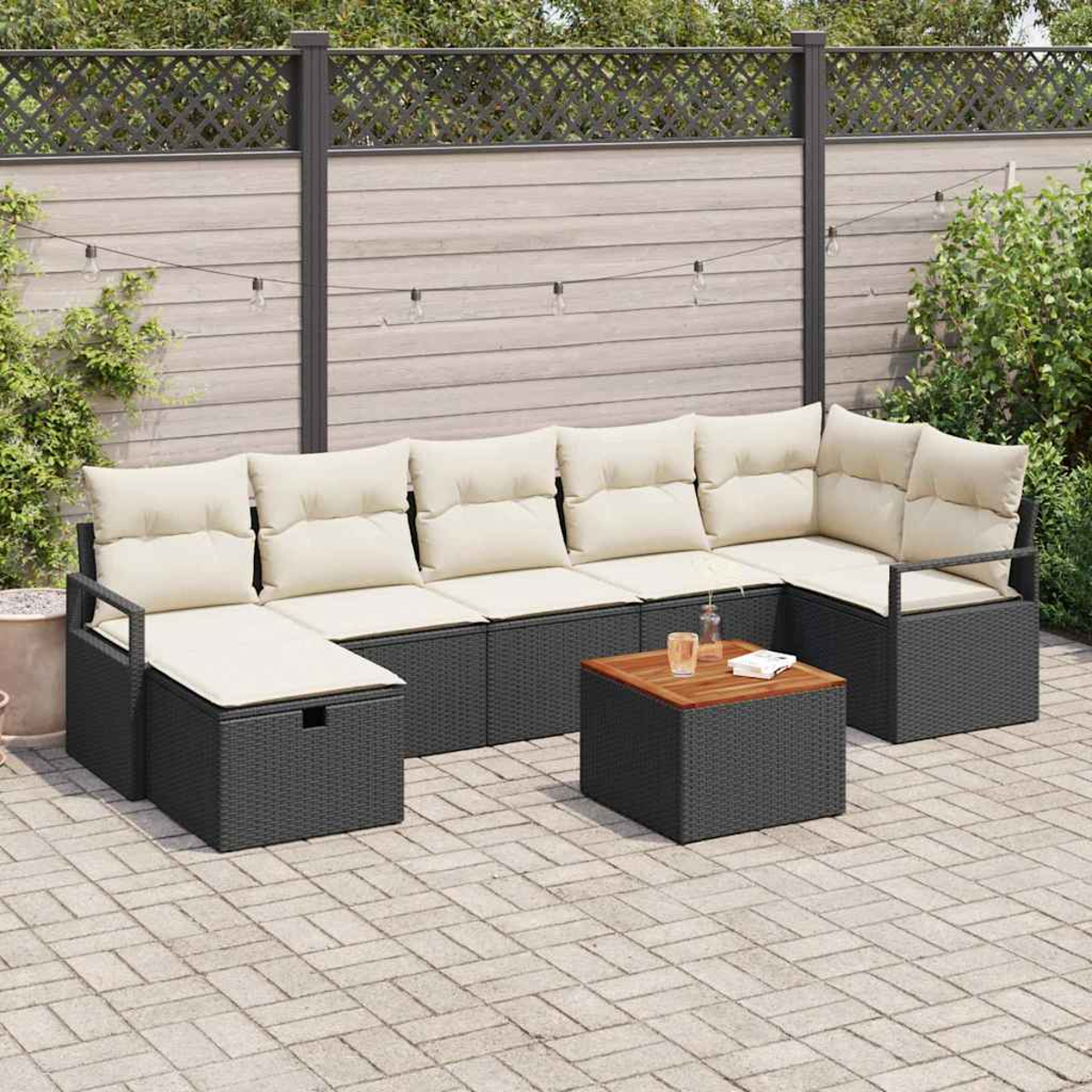 Ein Ecksofa im Freien mit cremefarbenen Kissen und einem Holztisch. Die Szene spielt auf einer Terrasse mit Zaun im Hintergrund.